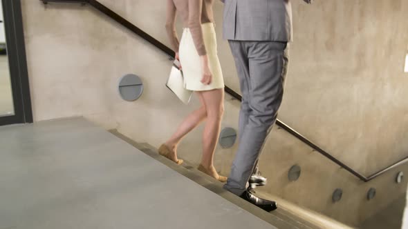 Businesswoman and Businessman Walking Downstairs 53