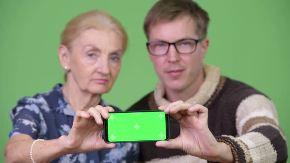 Happy Grandmother and Grandson Showing Phone Together