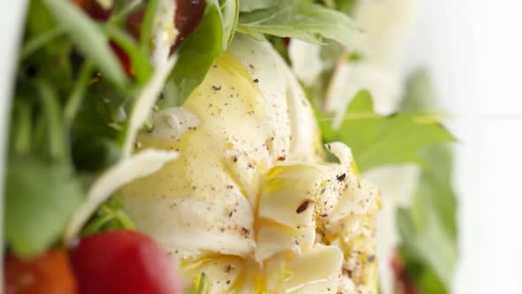 Vertical video: Mozzarella with salad in a plate