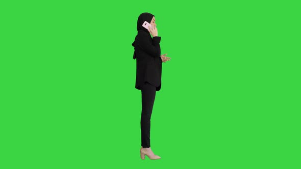 Arabic Business Woman Wearing Hijab Speaking on the Phone on a Green Screen, Chroma Key.