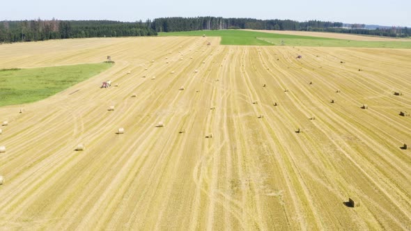 Aerial Drone Shot  a Field with Hay Bales in a Rural Area on a Sunny Day