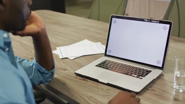 Video of african american man using laptop with copy space on screen