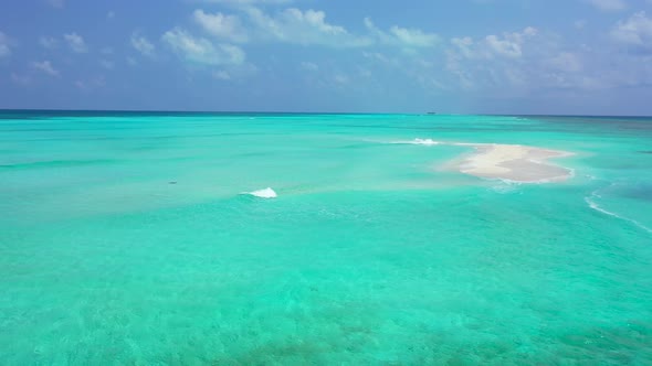 Paradise scenery of calm clear water on turquoise color around a tiny white sandy pile under bright