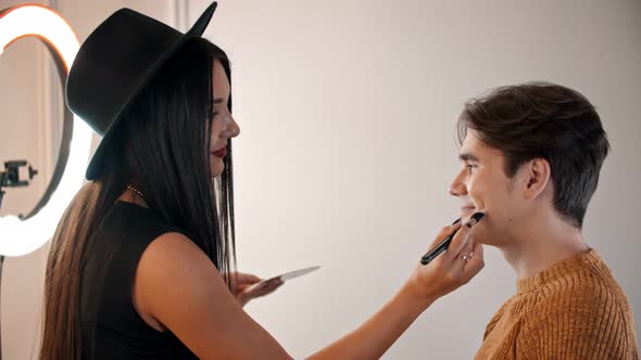 Make Up Artist Applying Base on the Face of Male Model