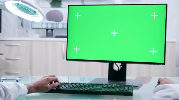 Male Doctor Hands Typing on Computer with Mock-up Green Screen