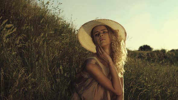 Young Girl Sitting in the Grass and Posing at the Camera