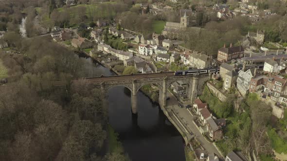 drone shot of train crossing a bridge