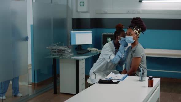 African American Doctor Using Otoscope for Ear Examination