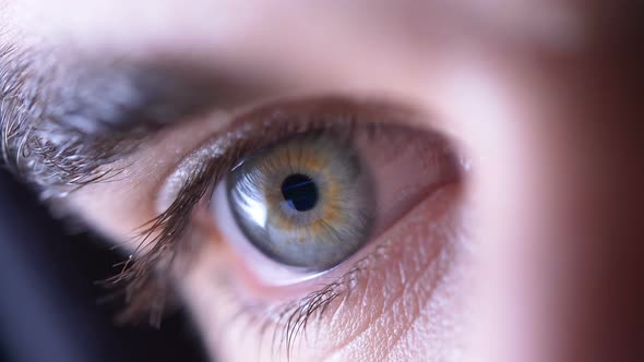 attractive man's closed eye opening in the dark- macro