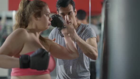 Portrait of Serious Fit Middle Eastern Man Training Overweight Caucasian Woman Talking