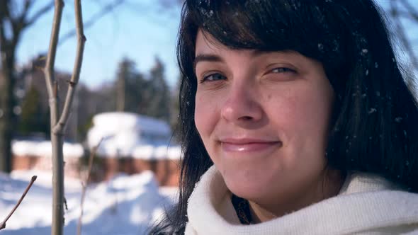 Close-up Pretty Female Face. Snowflakes On Hair. Young Adult In Snow Covered