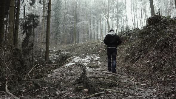 Anonymous man walking on snowy path