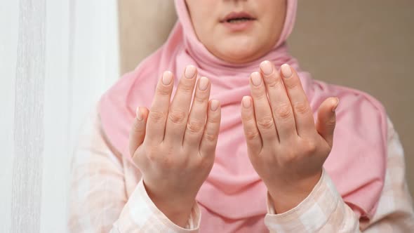 Unrecognizable Woman in Pink Hijab Reads a Prayer Holding Hands in Front of Her and Washes Face