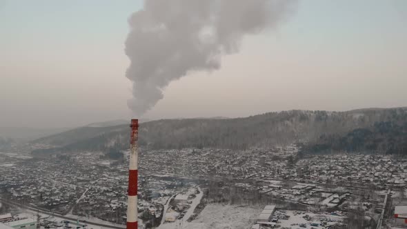 Industrial Zone with a Large Red and White Pipe Thick White Smoke is Poured From the Factory Pipe in