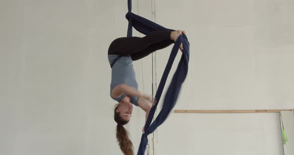 Gymnast is Training in the Gym Doing Tricks on Aerial Silks Sports