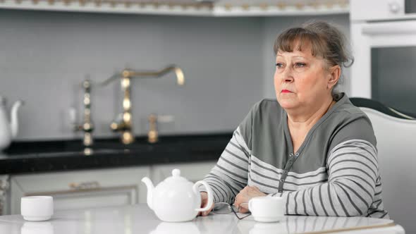 Lonely Wistful Unhappy Senior Lady Sitting on Table Having Coffee Break Have Depressed Emotion