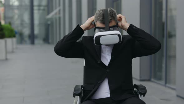 Crop View of Mature Businessman on Wheel Chair Wearing Virtual Reality Headset