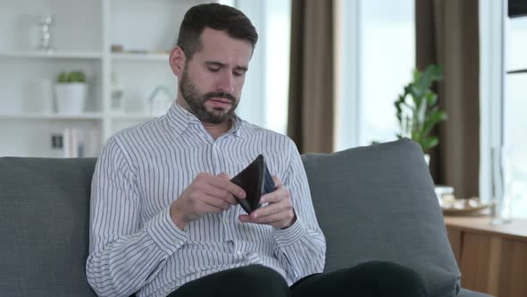 Worried Young Businessman Checking Empty Wallet at Home 