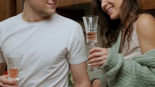 Romantic Couple That Enjoys a Glass of Wine and Relaxing in Kitchen