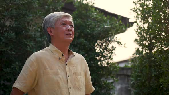 Portrait senior elderly Asian man smiling outdoors in nature.