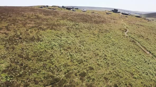 Flying over hilltops and tors in Dartmoor National Park, England.