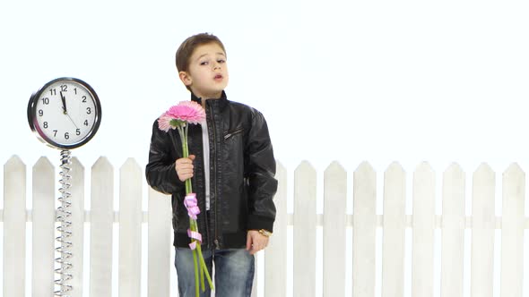 Little Boy with Flowers Is Waiting for His Girlfriend, She Comes They Are Happy and Kissing. White