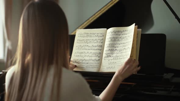 Girl Pianist with Hands Turn Over Musical Notes Close Up in Slow Motion