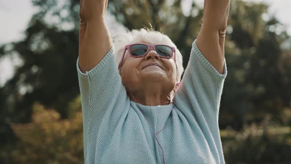 Senior Retired Woman Enjoying Freedom of Retirement. Outstretched Hands in the Park, Close Up