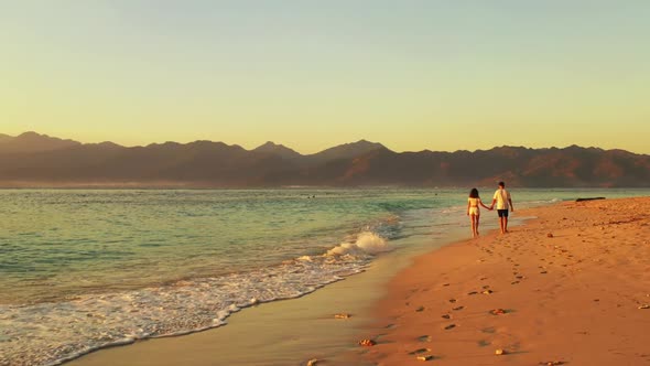 Romantic couple posing on tropical resort beach lifestyle by aqua blue ocean and white sandy backgro