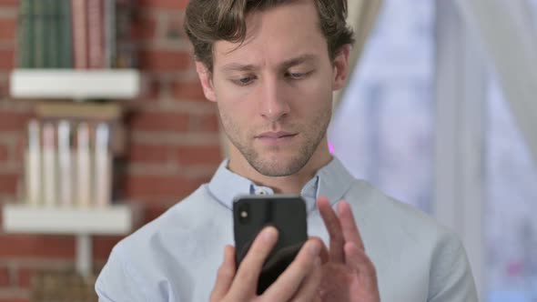 Portrait of Young Man Scrolling on Smartphone 