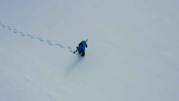 Aerial View of a Snowboard Going Uphill Near the Village at Sunset