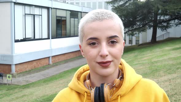 Young Caucasian Woman with Short Hair Looking at Camera on a University Campus