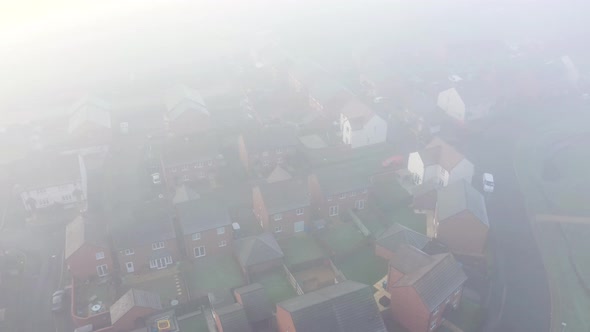 Aerial view of a residential estate covered by fog and clouds