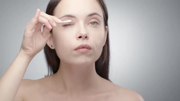 Woman Correcting Makeup with Q-tip