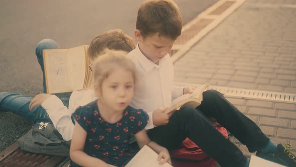 Little Girl Talks to Schoolmates at Preparation for Exams