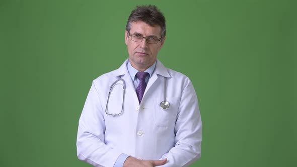 Mature Handsome Man Doctor Against Green Background