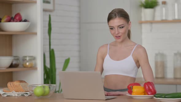 Athletic Woman Doing Video Call on Laptop in Kitchen