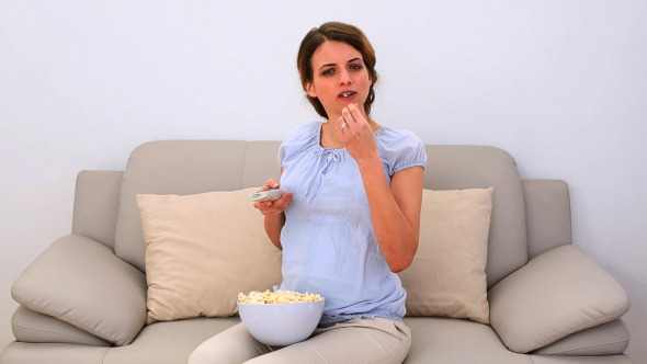 Pregnant Woman Watching Tv And Eating Popcorn