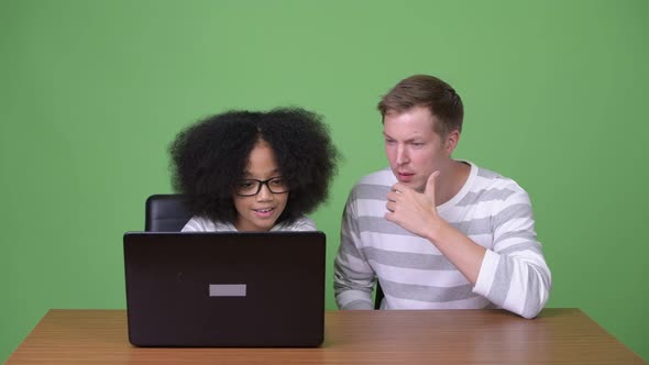 Young African Girl and Young Scandinavian Man Using Laptop Together