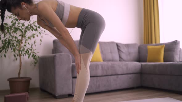 Flexible Woman Stretching Lower Back Doing Yoga at Home. Girl Doing Halasana Yoga Pose