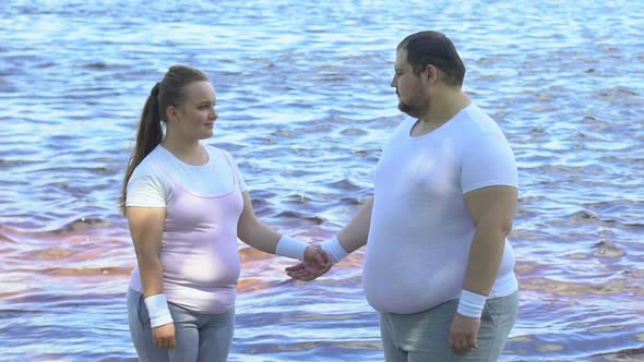 Pretty Overweight Female Hugging Her Boyfriend Near Waterfront, Tenderness