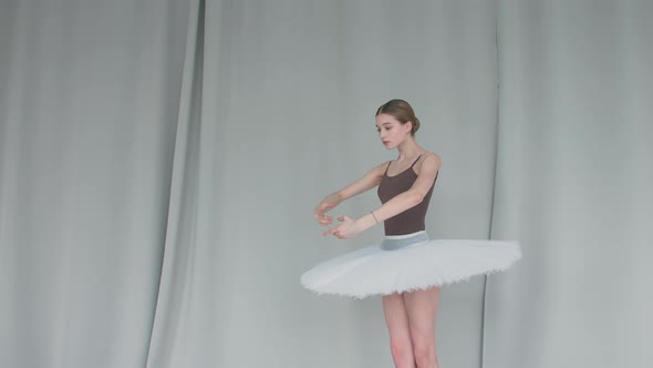 Ballerina on a Light Coloured Background Performs Smooth Movements with Her Hands. Graceful