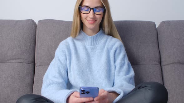 Cheerful blonde female using smartphone for communication online on social media app in 4k video