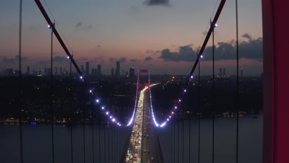 Epic Dolly Forward Through Istanbul Bosphorus Bridge Arch Illuminated in Red Light at Night with Car