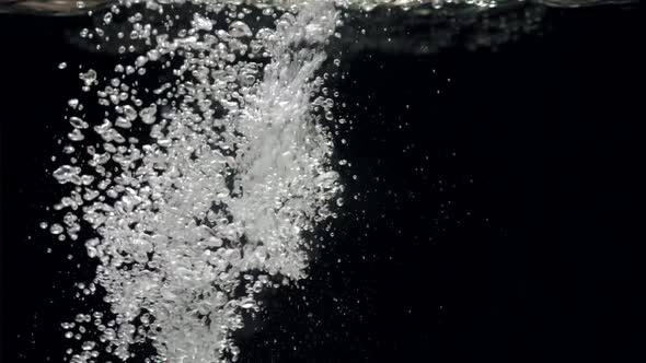 Slow Motion Stream of Water Drops Down in Aquarium on a Black Background