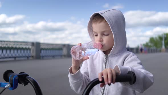 Cute 3 - 4 Years Boy Child Learning To Ride First Running Balance Bike and Drink Water