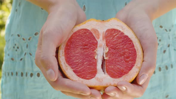 Grapefruit Half in Female Hands