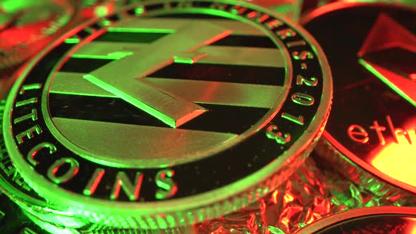 Cryptocurrency Litecoin in Macro Shot Rotate with Many Other Coins. Green and Red Light on It