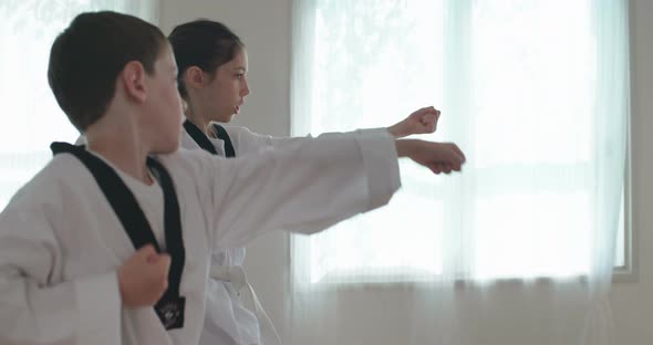 Slow motion footage of young kids practicing martial arts