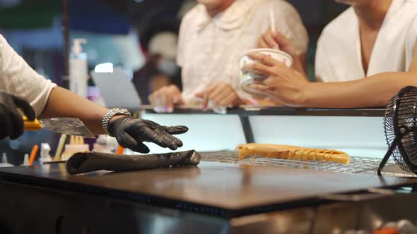 4K Portrait of Asian lgbtq guy friends in woman clothes eating street food together at night.